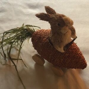 Straw rabbit riding in a carrot